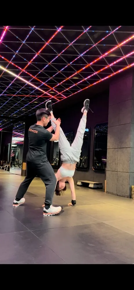 Jeremiah Lung spotting a client in a handstand