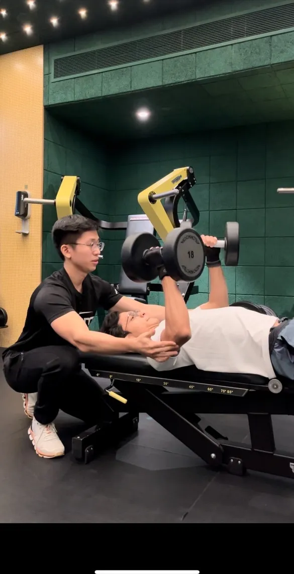 Jeremiah Lung coaching a client through a dumbbell press